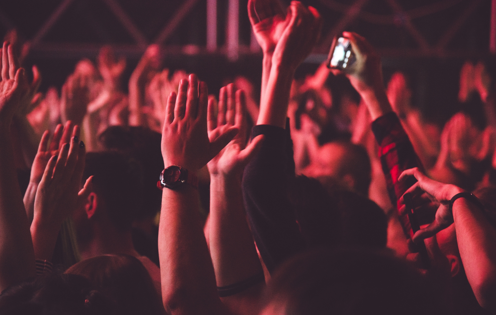 Stock photograph of hands raised in the air at a nightclub (Credits: Grigorii Postnikov via Getty)