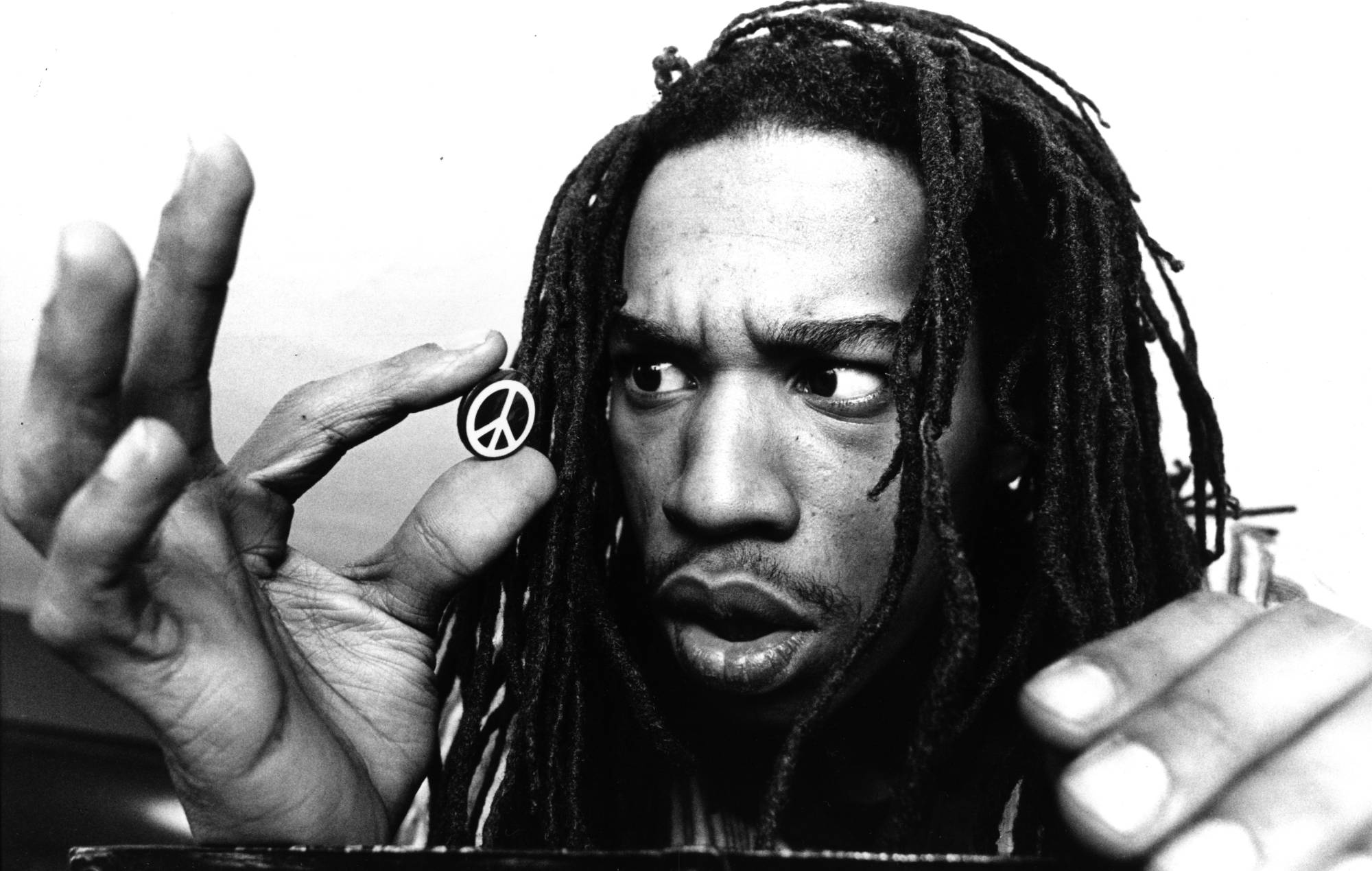 Le poète Benjamin Zephaniah inspecte de près un symbole du CND, 1982. (Photo de Michael Ward/Getty Images)